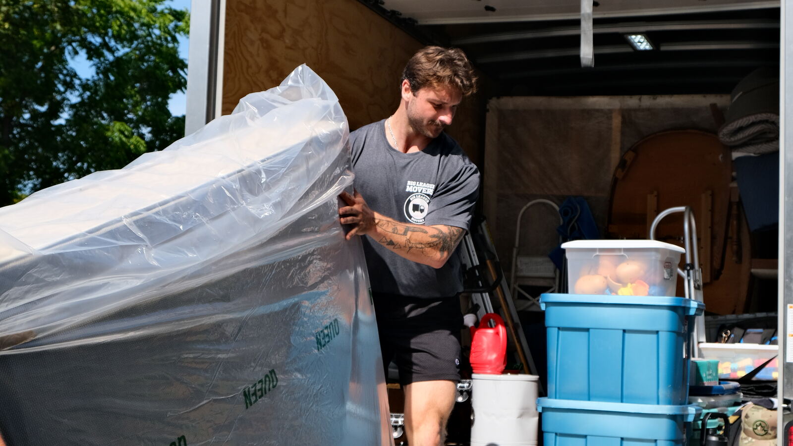 Big League Movers crew wrapping and loading furniture into the truck